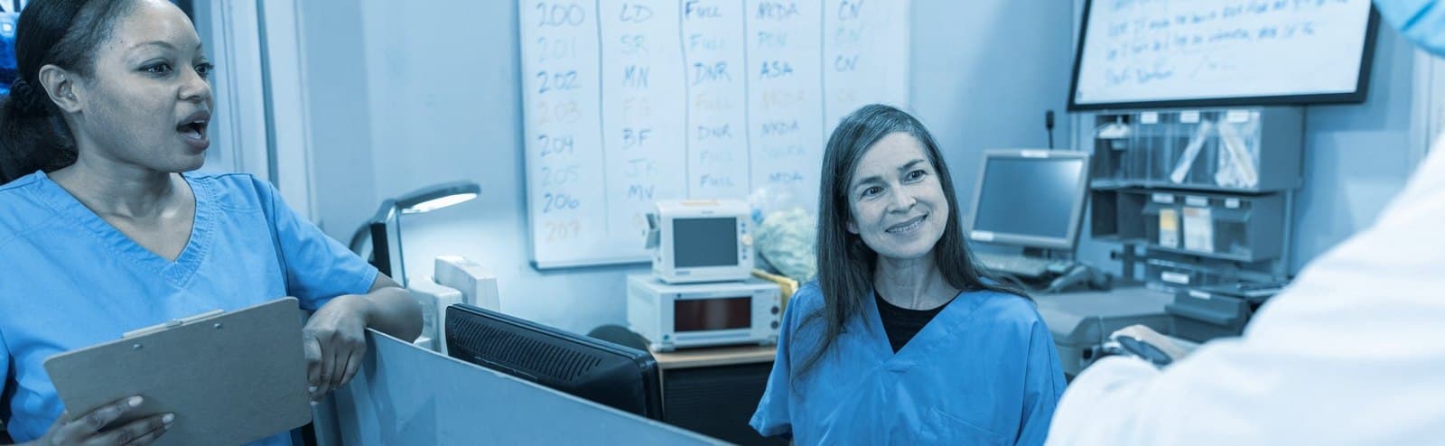 Two care-team members coordinating at a nursing station