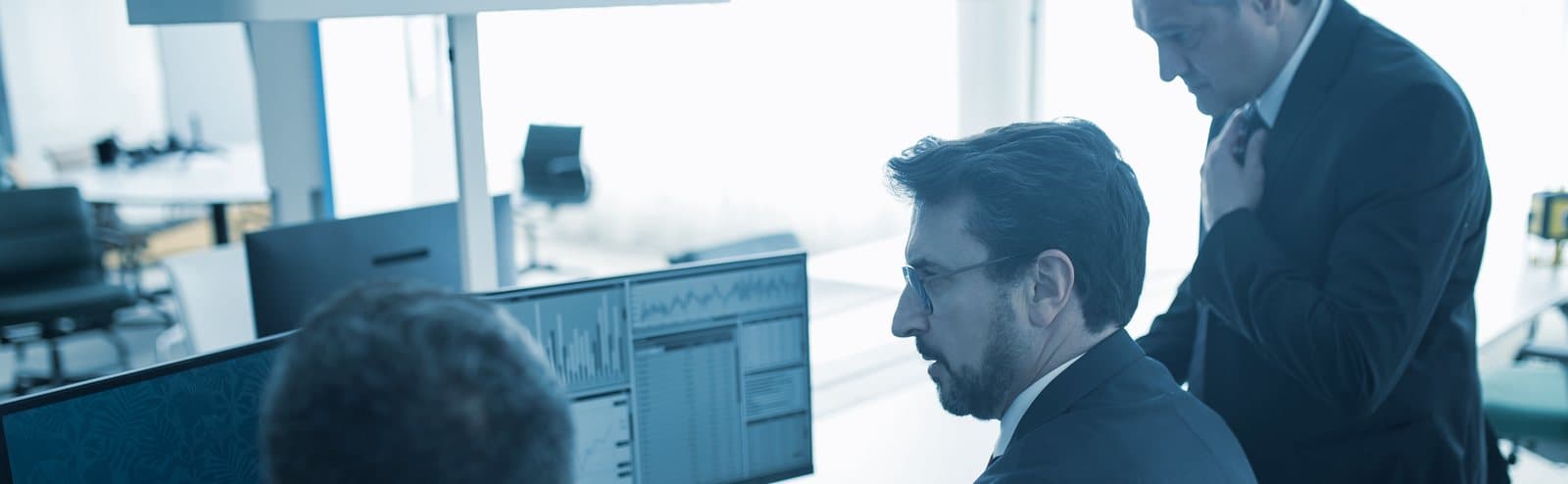 Two colleagues reviewing figures on a workstation